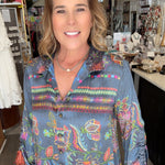 Woman wearing a colorful patterned shirt in a store setting