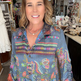 Woman wearing a colorful patterned shirt in a store setting