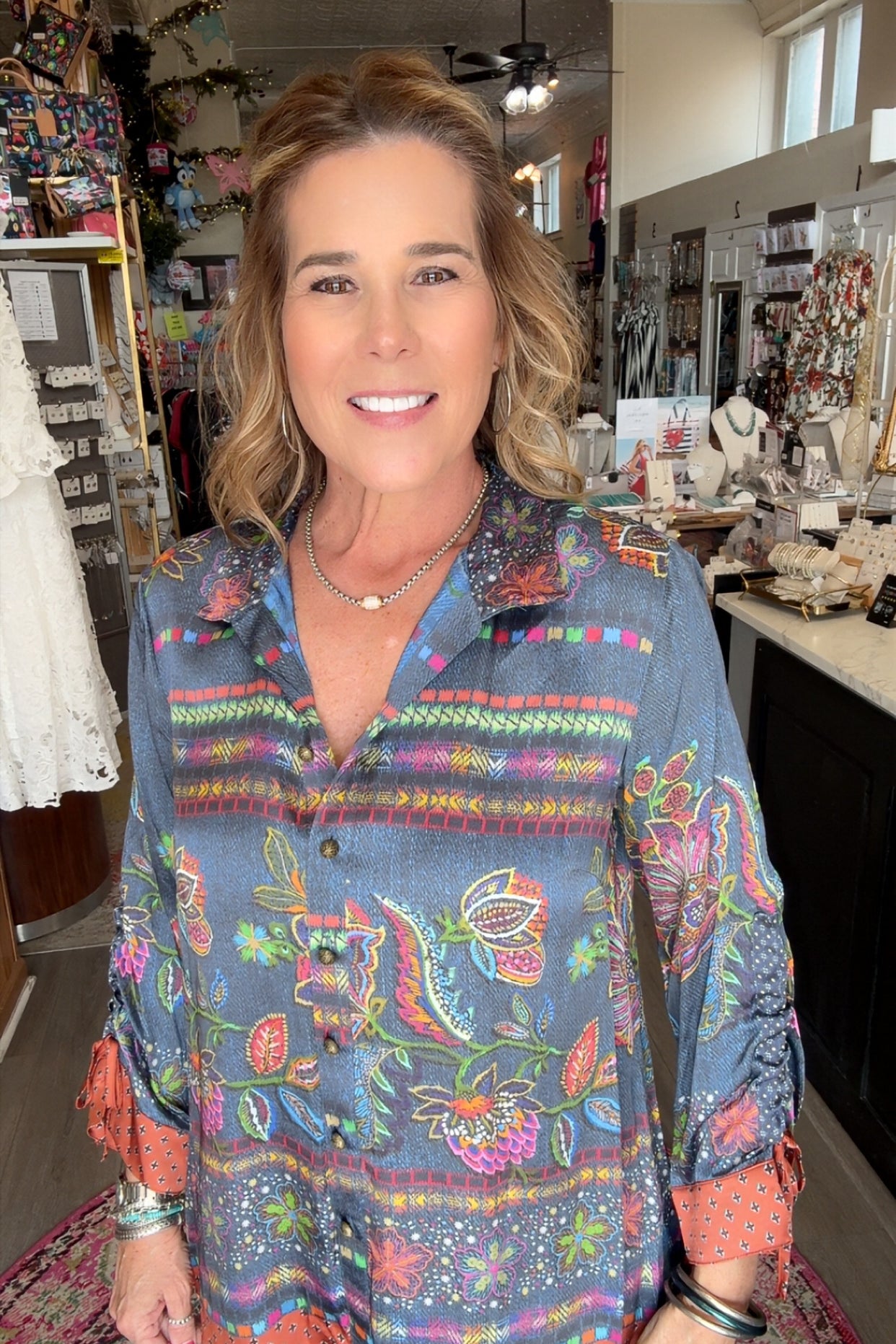 Woman wearing a colorful patterned shirt in a store setting