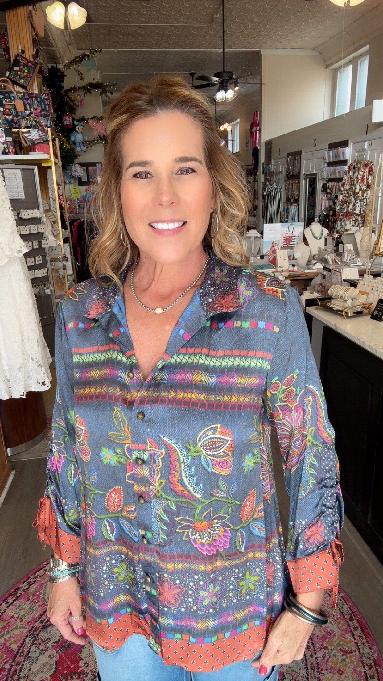 Woman wearing a colorful patterned shirt in a store setting