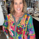 Woman wearing a colorful floral jacket in a store setting