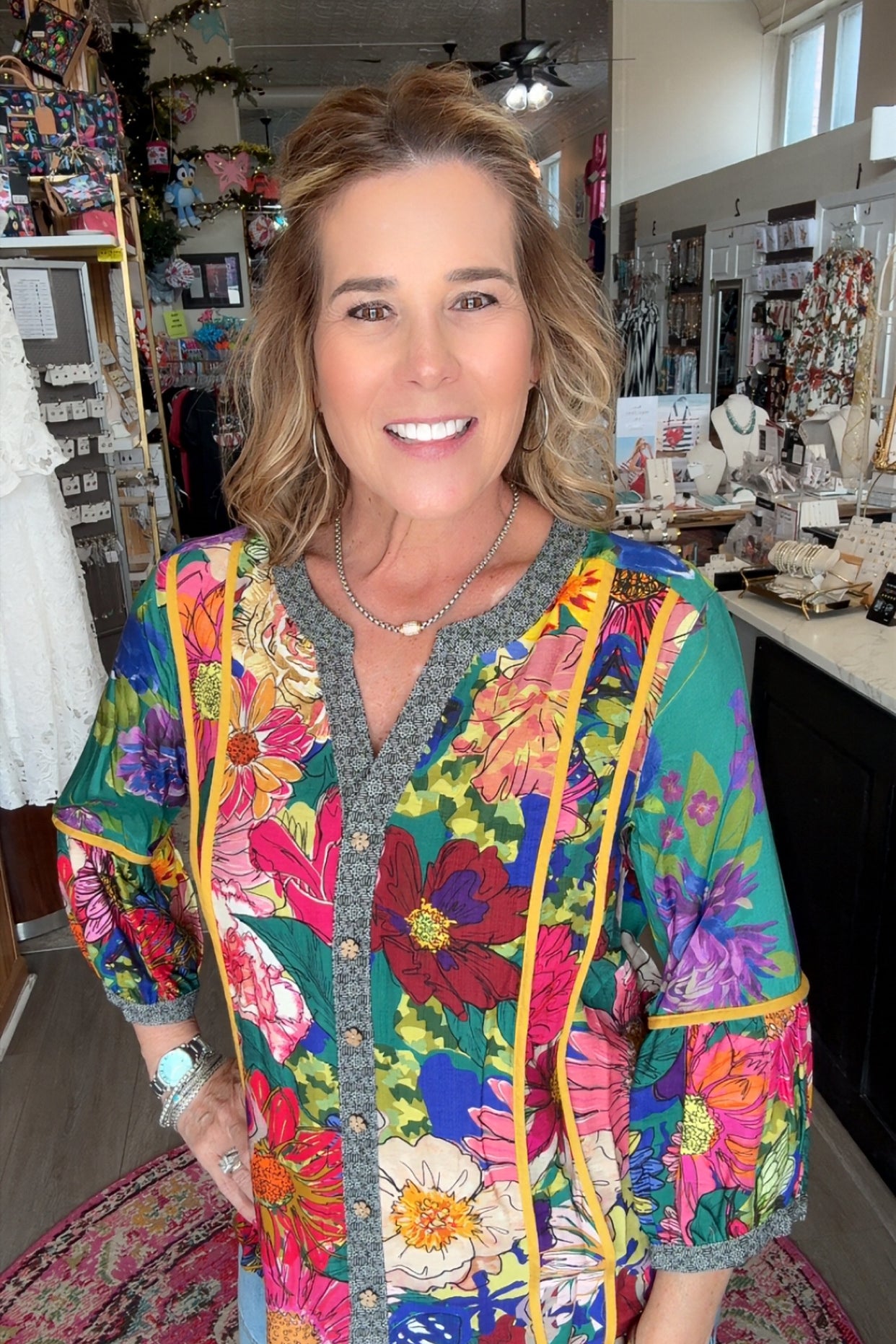 Woman wearing a colorful floral jacket in a store setting