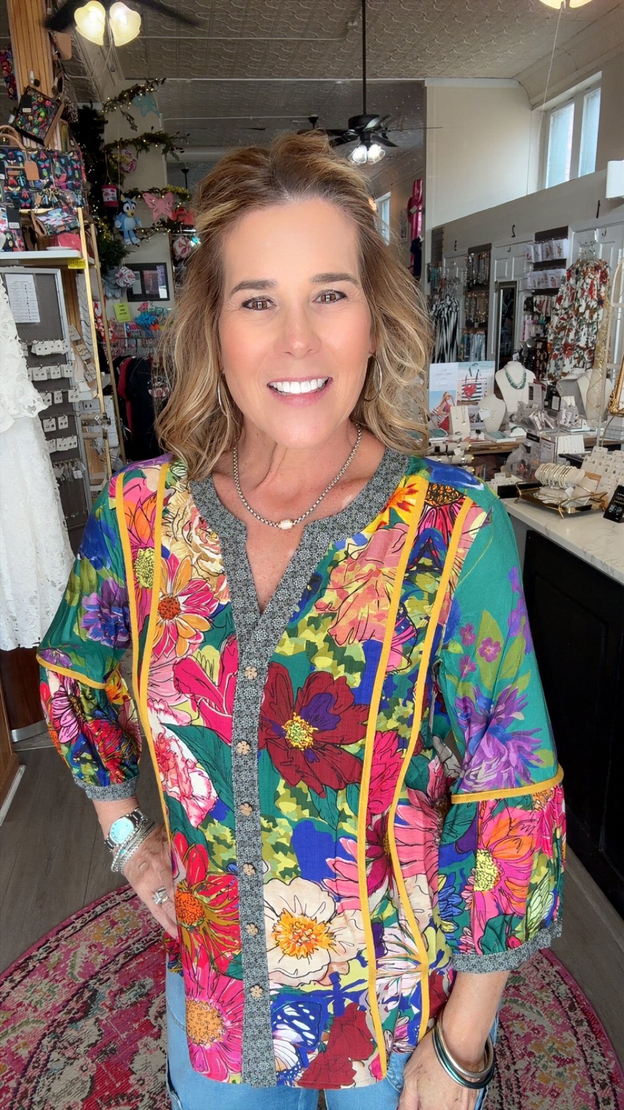 Woman wearing a colorful floral jacket in a store setting