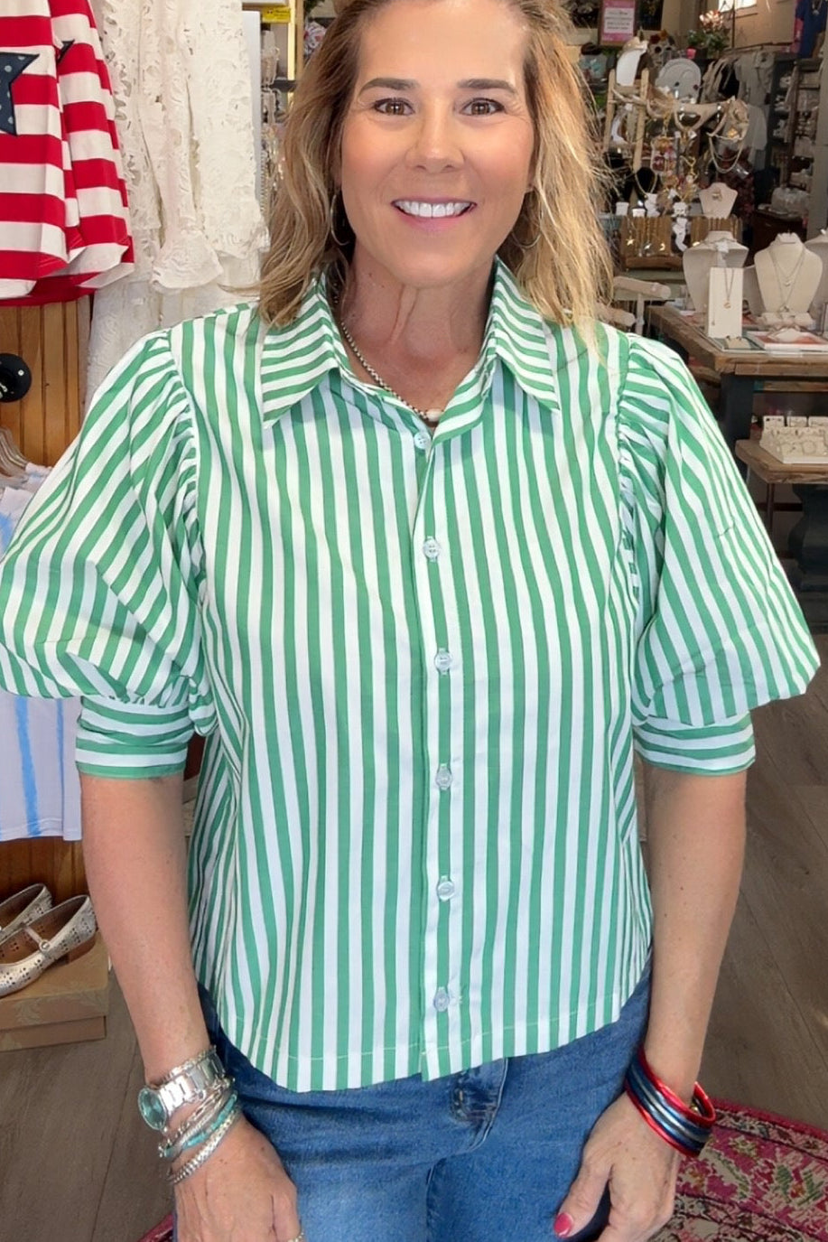 Woman wearing a green and white striped shirt in a store setting