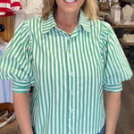 Woman wearing a green and white striped shirt in a store setting
