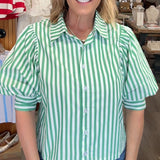 Woman wearing a green and white striped shirt in a store setting