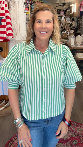 Woman wearing a green and white striped shirt in a store setting