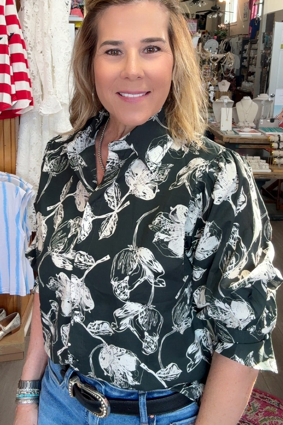 Woman standing in a store with clothing and decor in the background