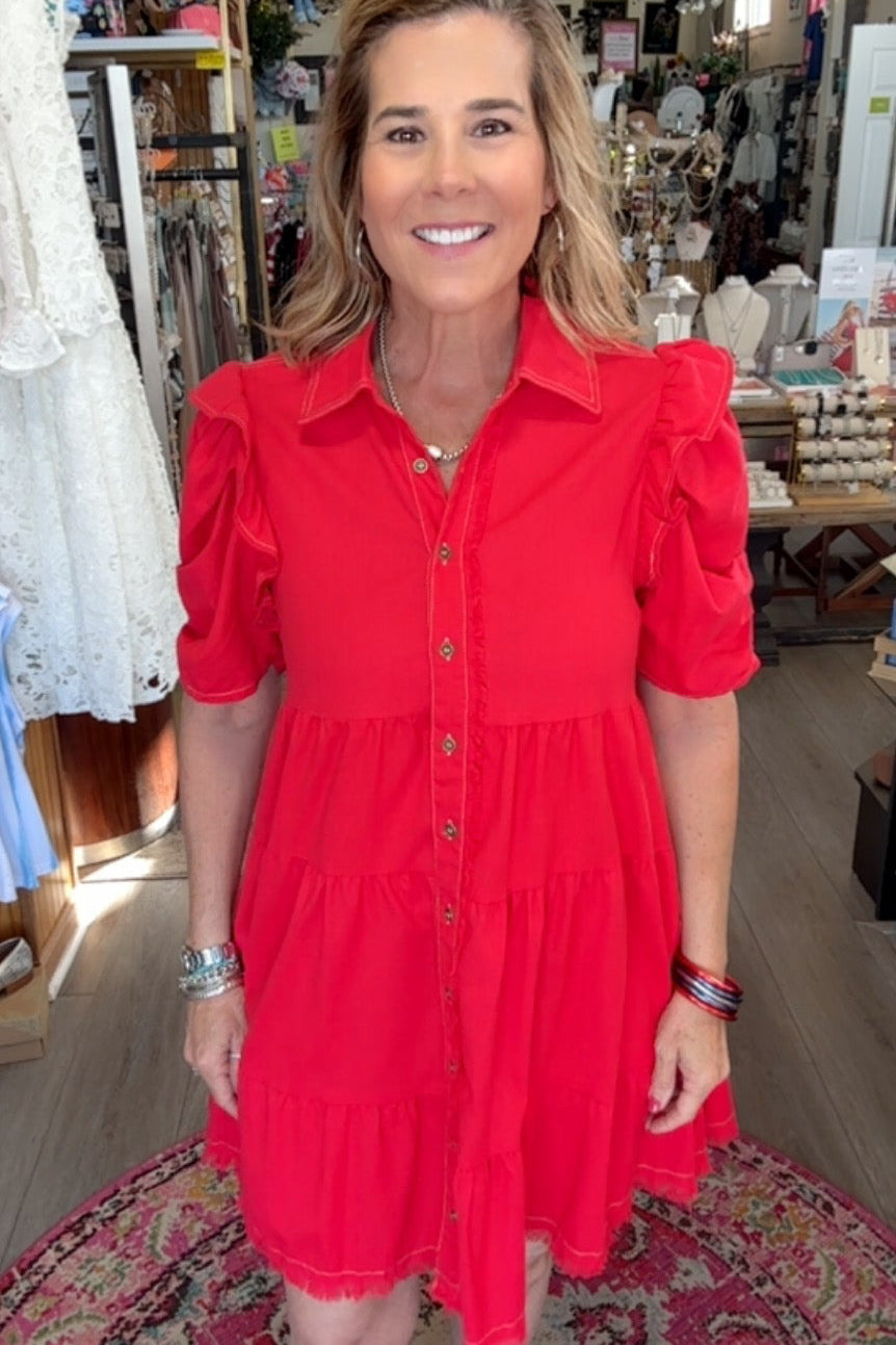 Woman in a red dress standing in a store with various items in the background