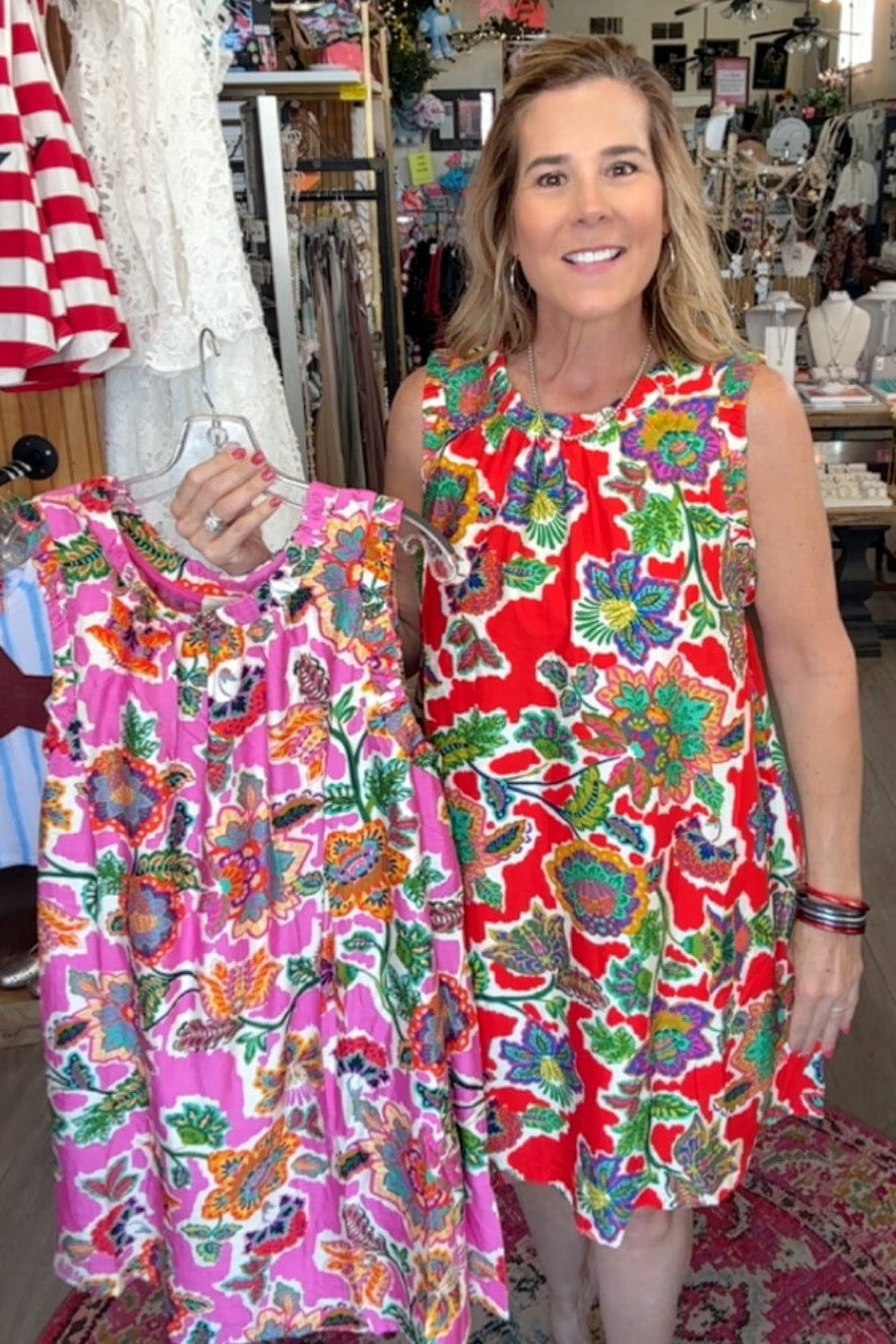 Woman holding a colorful dress in a store setting