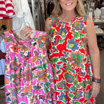 Woman holding a colorful dress in a store setting