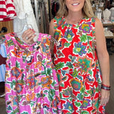 Woman holding a colorful dress in a store setting