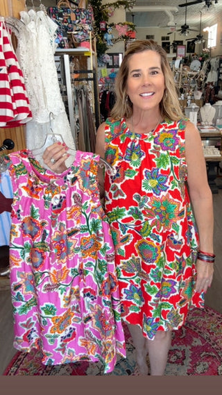 Woman holding a colorful dress in a store setting
