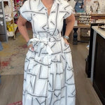 lady in geo pattern dress and wedges in a boutique.