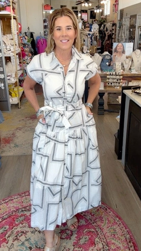 lady in geo pattern dress and wedges in a boutique.