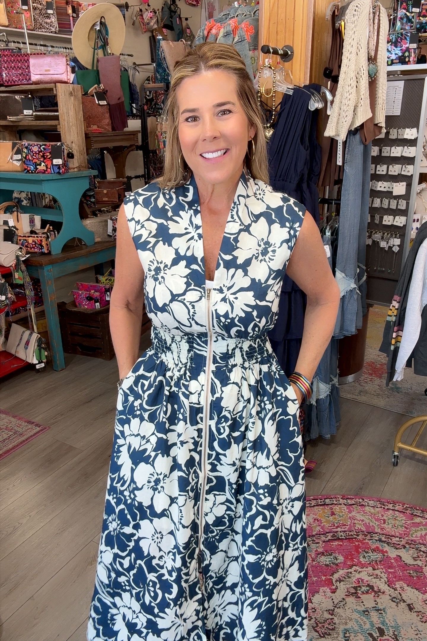 LADY in navy floral sleeveless dress with zipper front in a boutique