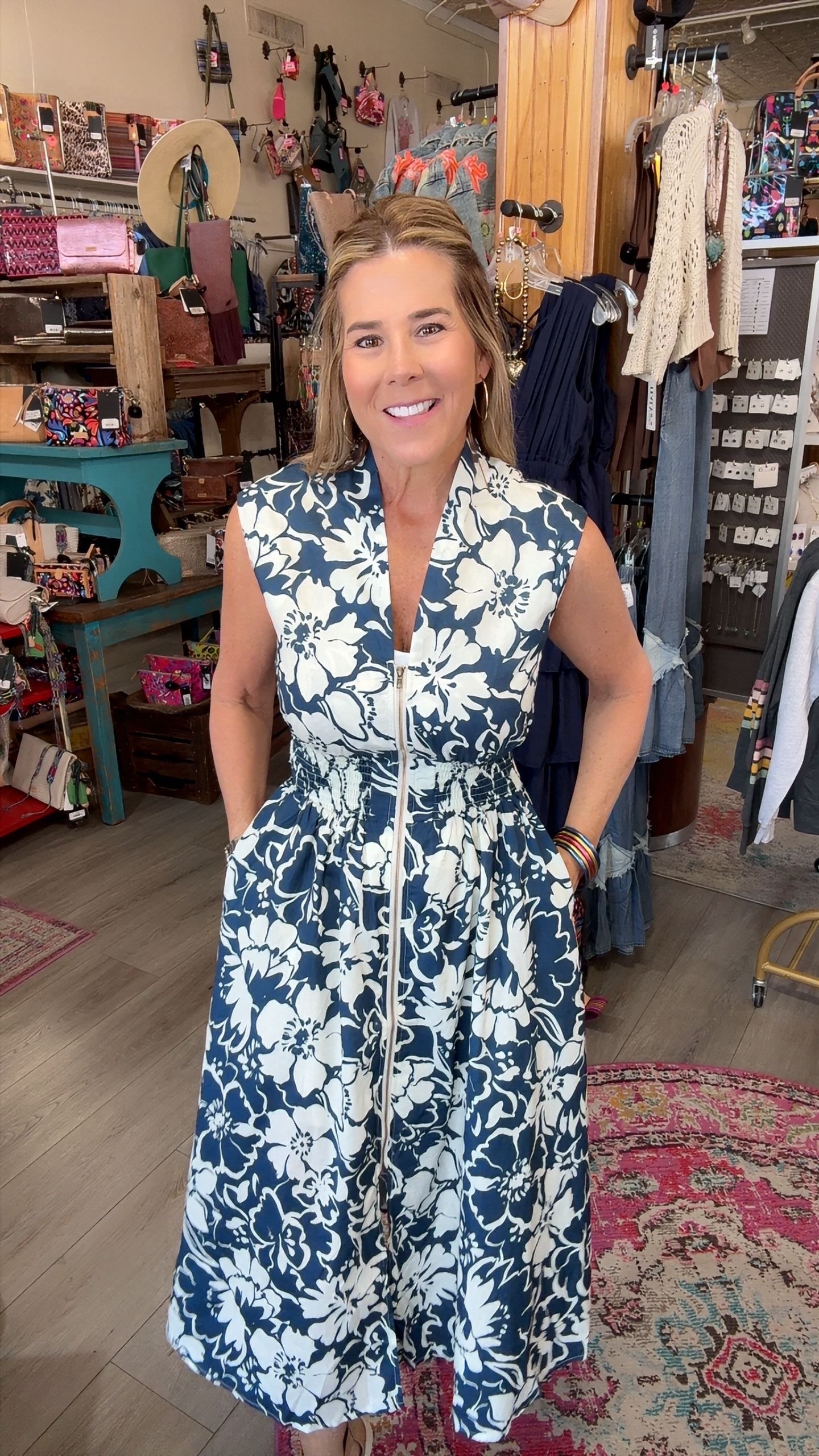 LADY in navy floral sleeveless dress with zipper front in a boutique