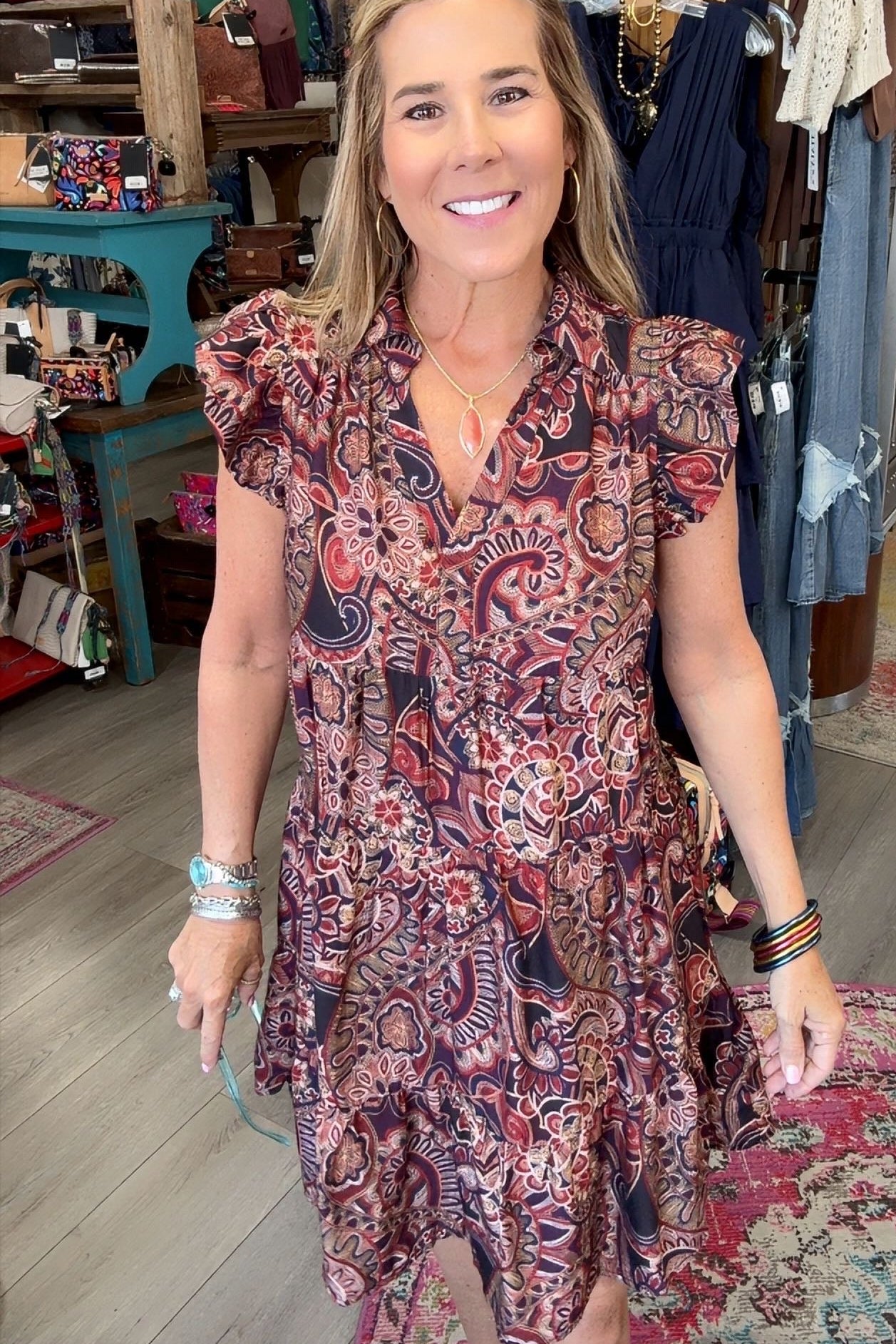 lady in floral paisley dress with ruffle sleeve in a boutique