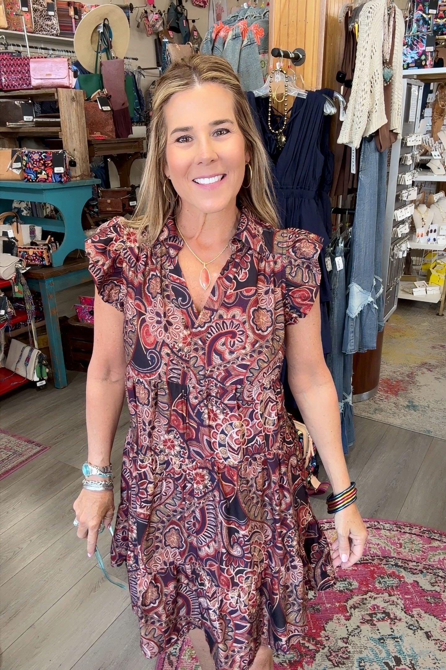 lady in floral paisley dress with ruffle sleeve in a boutique