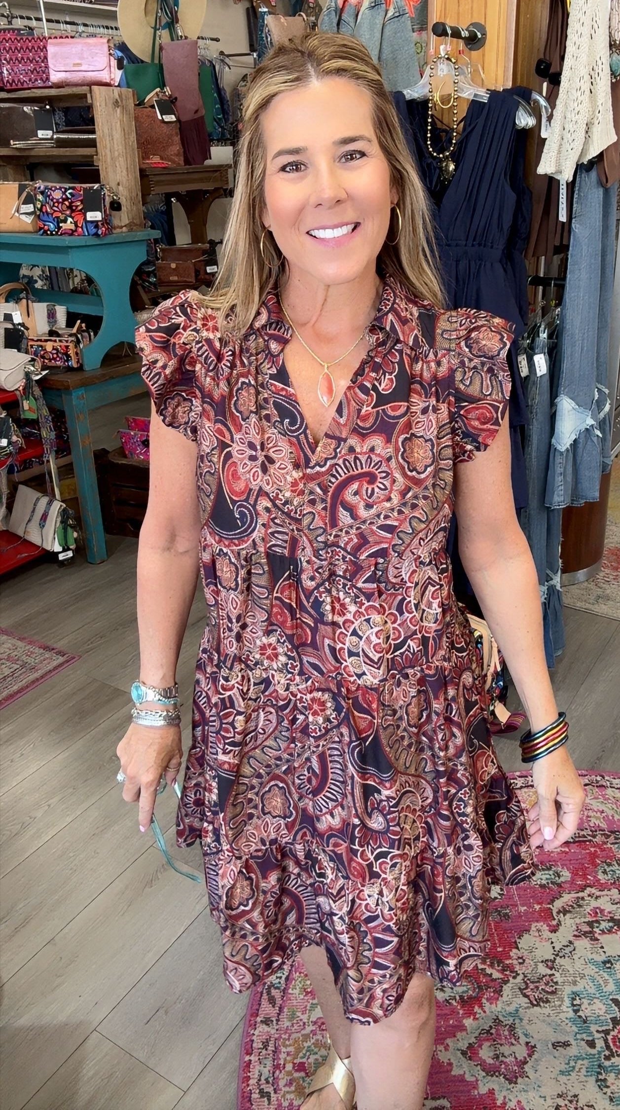 lady in floral paisley dress with ruffle sleeve in a boutique