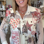 A smiling woman wearing a long-sleeve button-up shirt with a patchwork print featuring red, beige, brown, and white patterns, paired with blue jeans in what appears to be a retail store.
