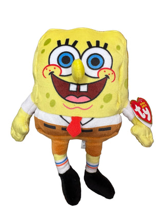A SpongeBob SquarePants plush toy by Ty, featuring the character with a yellow sponge head, white shirt, red tie, and brown pants, standing on a patterned carpet. A red Ty brand hangtag is visible on the right side.
