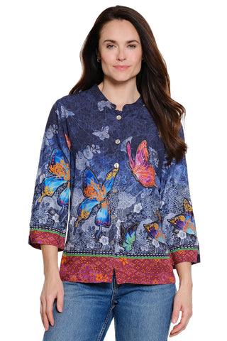 Woman wearing a colorful butterfly-patterned shirt on a white background