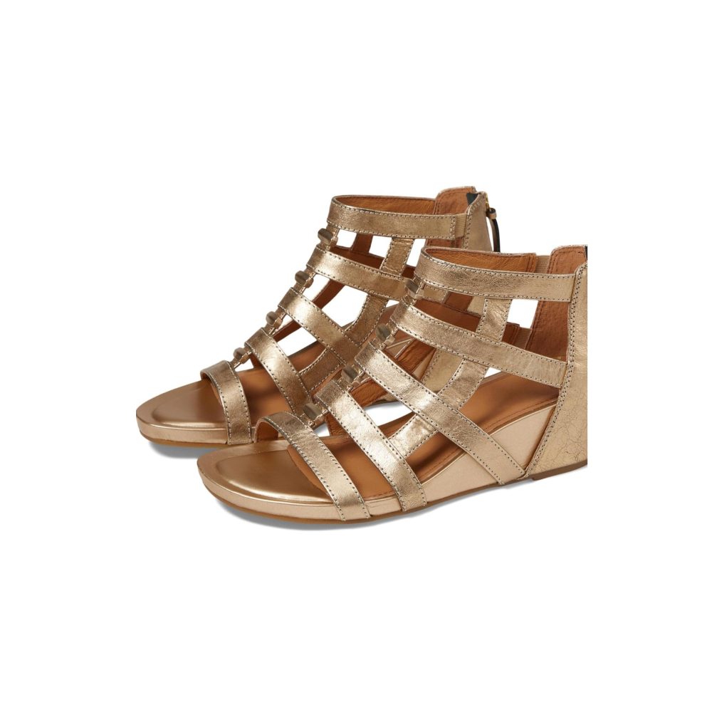 Gold wedge sandals with metallic finish on a white background