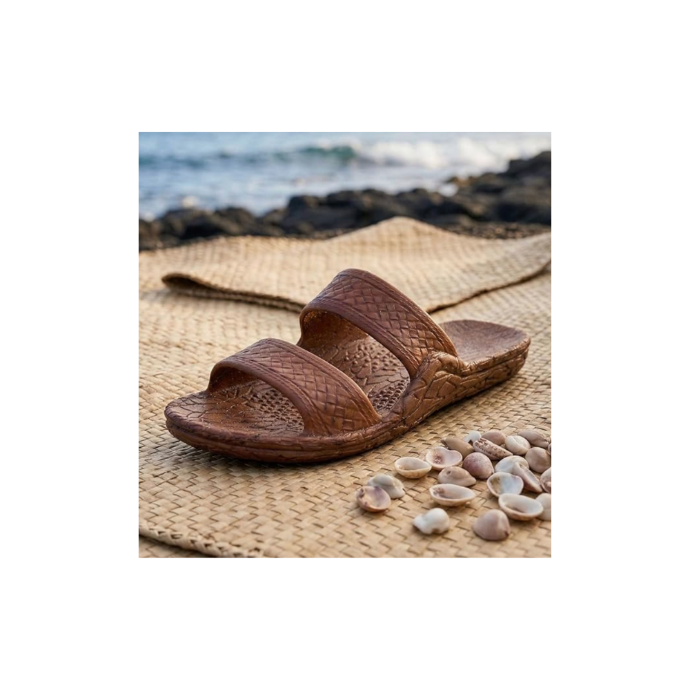 Brown sandal on a woven mat with seashells and ocean view