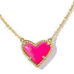 Neon pink heart-shaped pendant on a gold chain against a white background