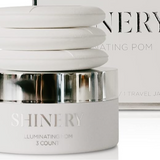 Skincare product jar labeled 'SHINERY' with a blurred magazine in the background