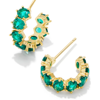 Gold hoop earrings with green gemstones on a white background