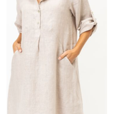 Beige button-up dress worn by a person on a white background