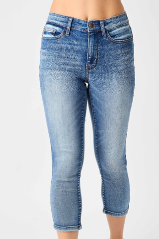 A pair of blue denim mid-rise capris with a front view on a plain background.