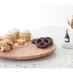 Wooden cutting board with cookies on a white surface