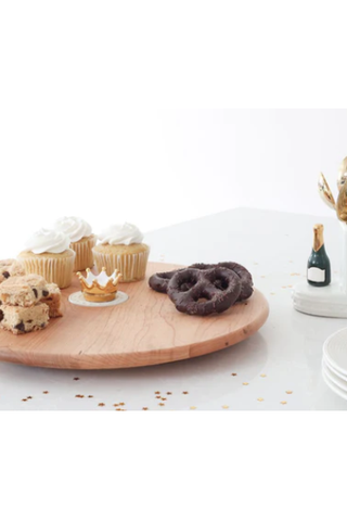 Wooden cutting board with cookies on a white surface