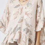 Woman wearing a floral blouse with a neutral background
