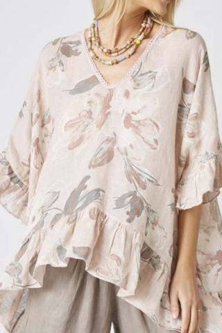 Woman wearing a floral blouse with a neutral background