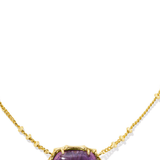 A gold-colored bamboo-textured necklace with a sage green serpentine pendant on a white background.