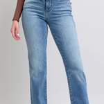 Person wearing blue jeans on a plain background