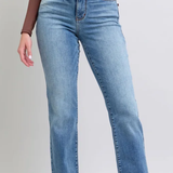 Person wearing blue jeans on a plain background