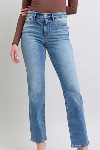 Person wearing blue jeans on a plain background