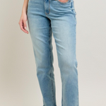 Person wearing light blue jeans with a plain background