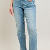 Person wearing light blue jeans with a plain background