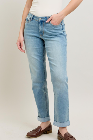 Person wearing light blue jeans with a plain background