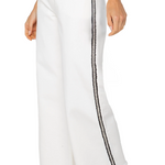 White pants with black side stripes worn by a person on a white background