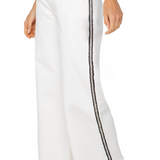 White pants with black side stripes worn by a person on a white background