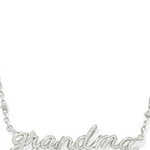 A silver-colored Grandma necklace with a crystal embellishment on the pendant, designed in a cursive script.
