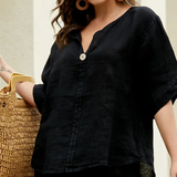 Woman in a black outfit holding a straw bag in an outdoor setting