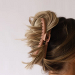 Hairbrush in a person's hair on a white background